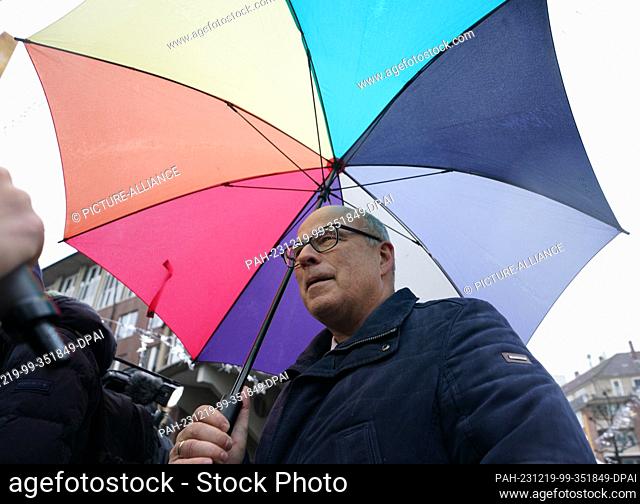 19 December 2023, Hamburg: Ties Rabe (SPD), Senator for Schools and Vocational Training in Hamburg, stands under an umbrella on the Michaelis Bridge