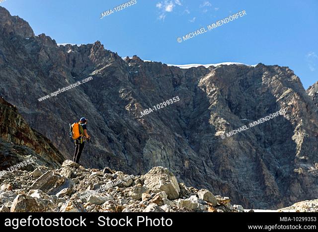 Switzerland, Valais, Haute Route Chamonix Zermatt, mountain climber looks at the Wandfluehorn