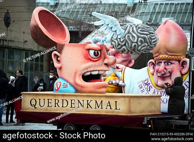 15 February 2021, North Rhine-Westphalia, Duesseldorf: A motto float with a figure with an opened skull, above it a brain with wings and the inscription...