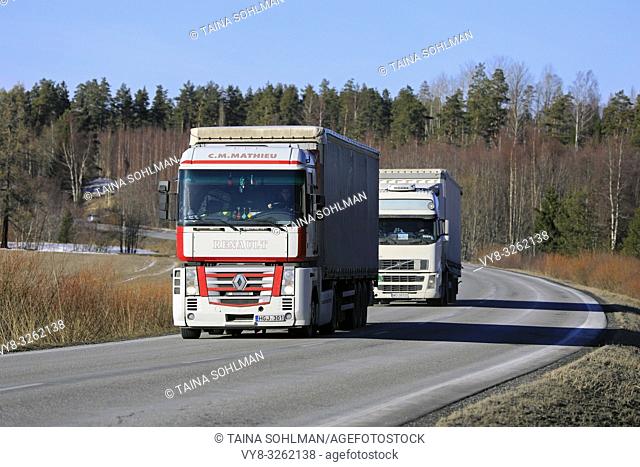 Salo, Finland - March 1, 2019: Two white semi trucks, Renault Magnum C. M. Mathieu in the front, transport goods on Finnish highway in early spring