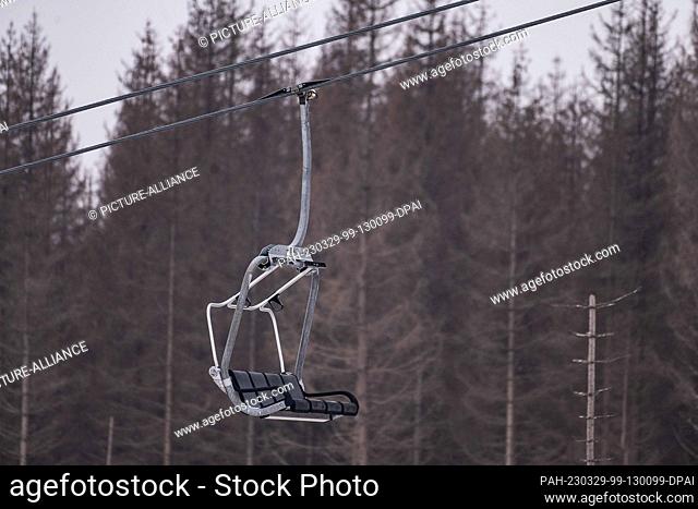 29 March 2023, Lower Saxony, Braunlage: A gondola from the Hexenritt chairlift in front of spruces on the Wurmberg in the Harz mountains