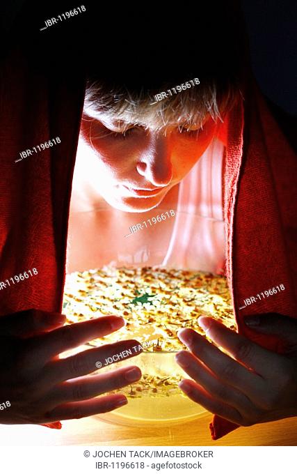 Young woman inhaling vapours from an herbal infusion of dried chamomile blossoms, as a remedy against a cold