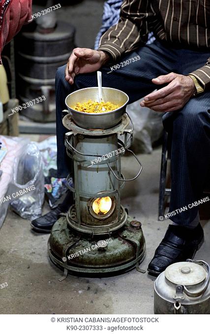 Bazari sitting in front of his meal prepared on a small oven, Bazar-e Bozorg in Esfahan, Isfahan, Iran, Asian