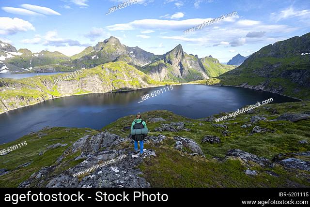 Young woman with backpack, mountain landscape with lake Tennesvatnet, hiking to Munken, Moskenesöy, Lofoten, Nordland, Norway, Europe
