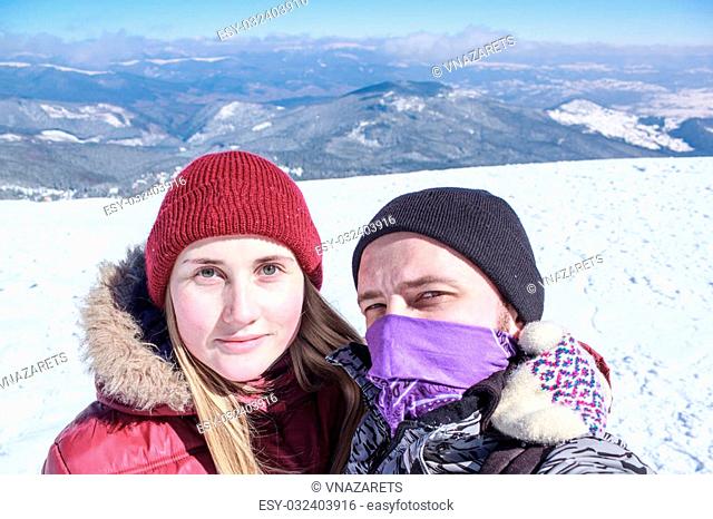 man and woman doing selfie in the snowy mountains