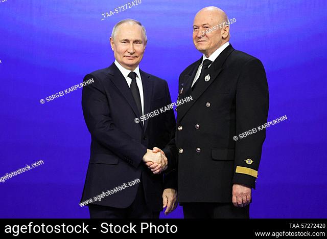 RUSSIA, MOSCOW - FEBRUARY 9, 2023: Russia's President Vladimir Putin (L) awards the title of Honoured Pilot to Utair flight detachment commander Sergei Kokorin...
