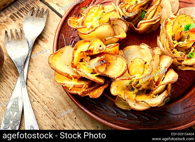 Fried potato with bacon on plate over wooden table