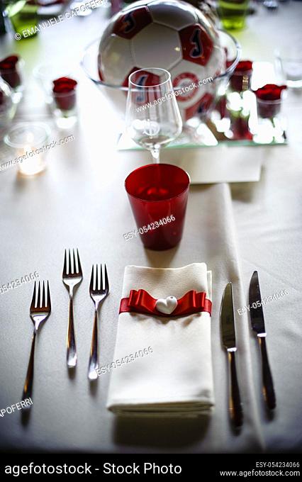 Cutlery and napkin noodle and ceramic heart above table set for wedding