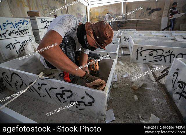 12 November 2020, Iraq, Najaf: A worker assembles gravestones at a workshop for making coffins, gravestones and markers near the Wadi al-Salam (Valley of...