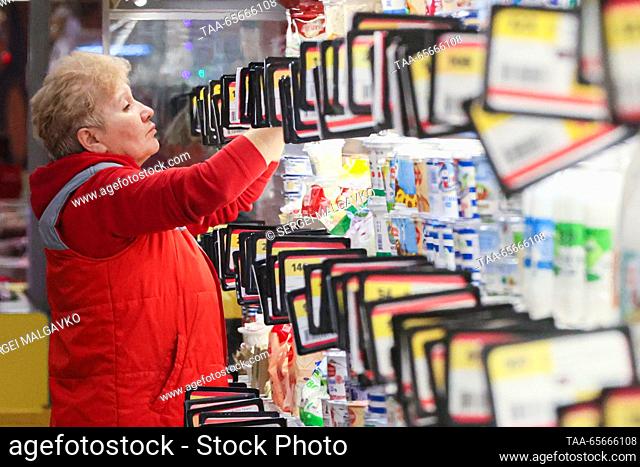 RUSSIA, SIMFEROPOL - DECEMBER 12, 2023: A staff member arranges dairy products on the shelves at the 7M Beztsen superstore during the Christmas season