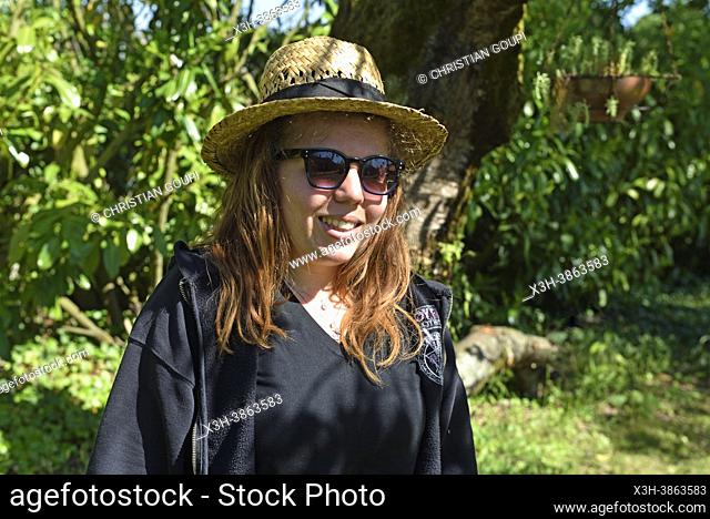 Portrait de jeune femme portant des lunettes de soleil et un chapeau de paille, Foret de Rambouillet, Parc naturel regional de la Haute Vallee de Chevreuse