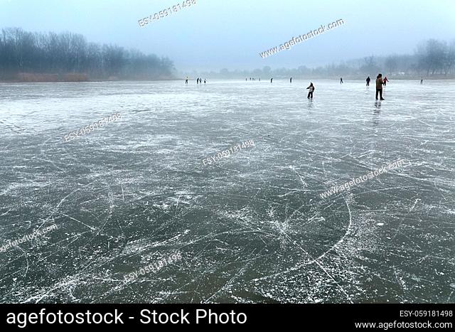 Frozen lake with people skating in the distance