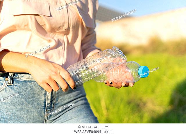 Woman's hands holding empty plastic bottles, close-up
