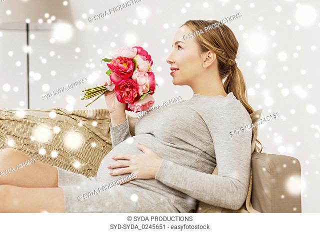 happy pregnant woman with flowers at home