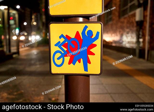 Bicycle traffic warning sign on a sidewalk