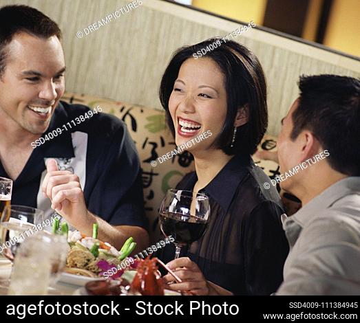 Asian woman laughing at restaurant table