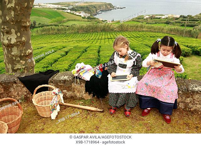 Young girls doodling on slate boards while wearing traditional garments  Porto Formoso, Sao Miguel, Azores, Portugal