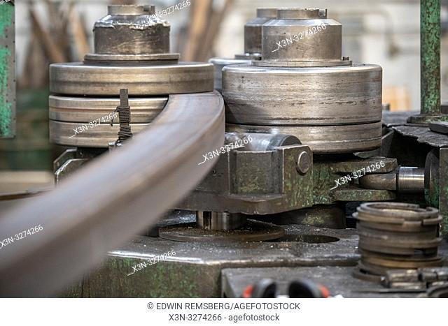 Machine rolling steel into a curve at metal bending shop, Dundalk, Maryland