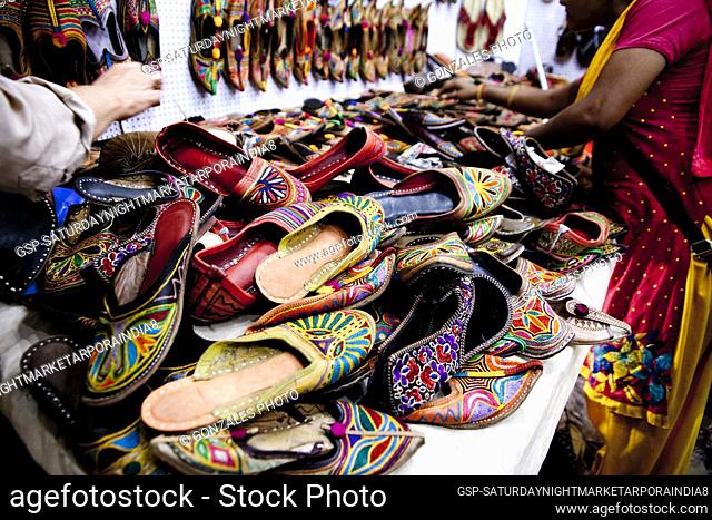 Shoe seller at the Saturday Night Market in Arpora, India. The market is open every Saturday during the tourist Season. There is a great selection of everything...