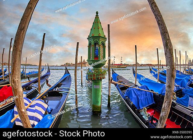 Sunset view of gondolas at St Mark's Square with the island of San Giorgio Maggiore behind , with its church front designed by Andrea Palladio and begun in 1566