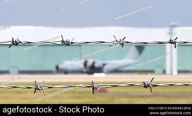 15 August 2021, Lower Saxony, Wunstorf: A view through barbed wire at the Wunstorf Air Base of the German Air Force in the Hanover region of an Airbus A400M...