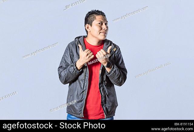 Handsome man pointing to the side, friendly guy pointing his fingers to the side, young man pointing at blank space