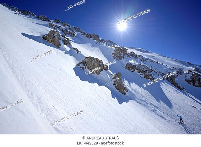 Female backcountry skier ascending through bold cirque to Monte Amaro, Rava della Vespa, Maiella, Abruzzo, Italy