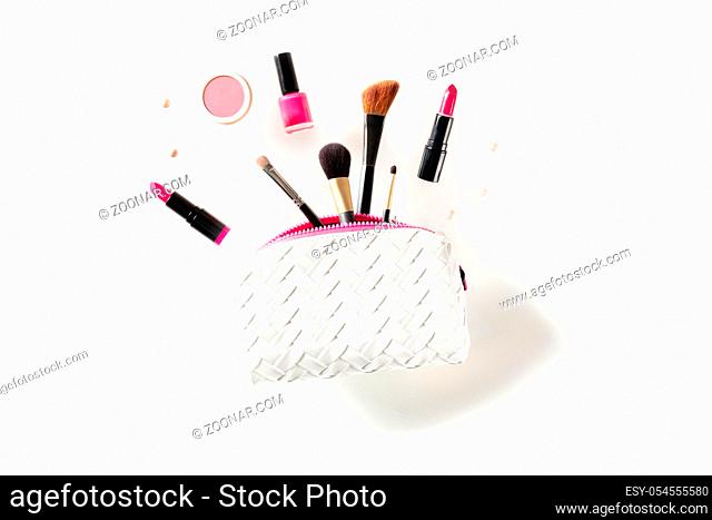 Professional makeup, flying out of a pouch, on a white background