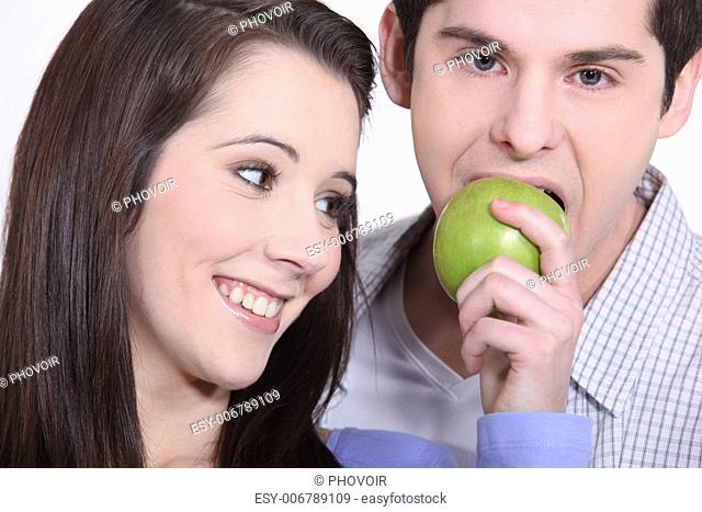 young man eating apple and girlfriend