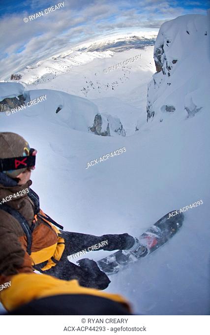 A snowboarder takes a POV angle as he rides his splitboard into a steep couloir, Kicking Horse backcountry, Golden, Britsh Columbia, Canada