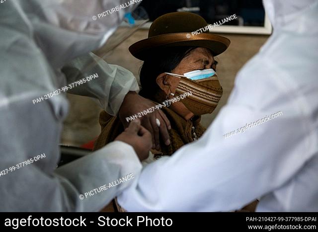 27 April 2021, Bolivia, La Paz: A woman with double oral-nasal protection is administered the Corona vaccine Sputnik V. The current vaccination campaign is...