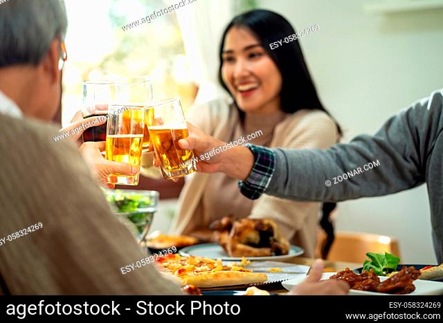 Happy asian multigenerational family of dad mom daughter girl and grandfather cheers together during lunch meal together with joyful