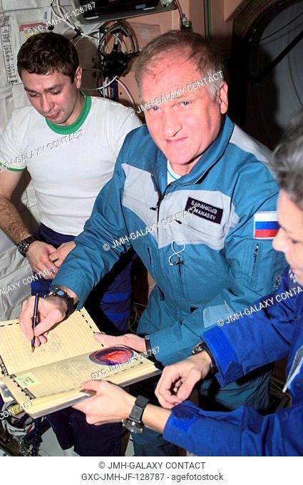 The Soyuz Taxi crewmembers, Flight Engineer Konstantin Kozeev (left), Commander Victor Afanasyev and French Flight Engineer Claudie Haignere add their names to...