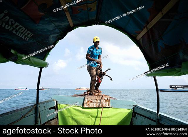 04 August 2021, Tanzania, Sansibar: A fisherman weighs anchor in a tour boat. Photo: Sebastian Kahnert/dpa-Zentralbild/dpa