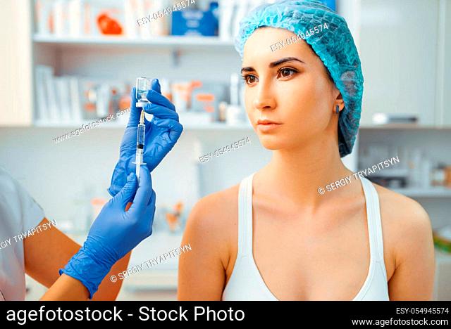 Cosmetician makes botox therapy to female patient on treatment table. Rejuvenation procedure in beautician salon. Doctor and woman