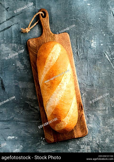 British White Bloomer or European Baton loaf bread on gray background. Top view or flat lay. Copy space for text or design. Vertical