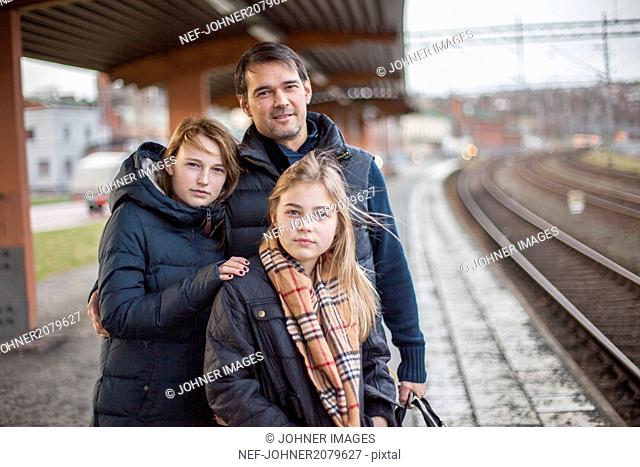 Father with daughters at train station