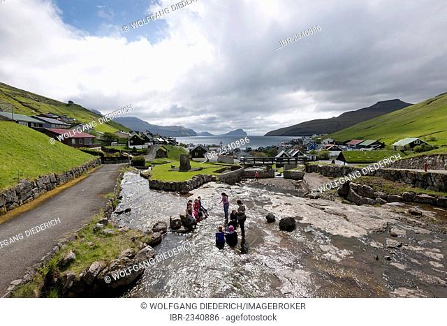 School children taking a break in a cold stream, village of Kvívík, Faroe Islands, Denmark, Northern Europe, Europe