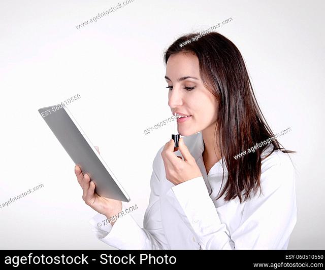 Geschäftsfrau mit digital tablet und Lippenstift  businesswoman with lipstick using digital tablet as a mirror