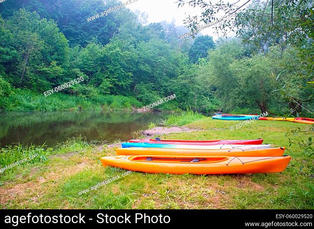 double kayaks on the shore, ten kayaks near the river