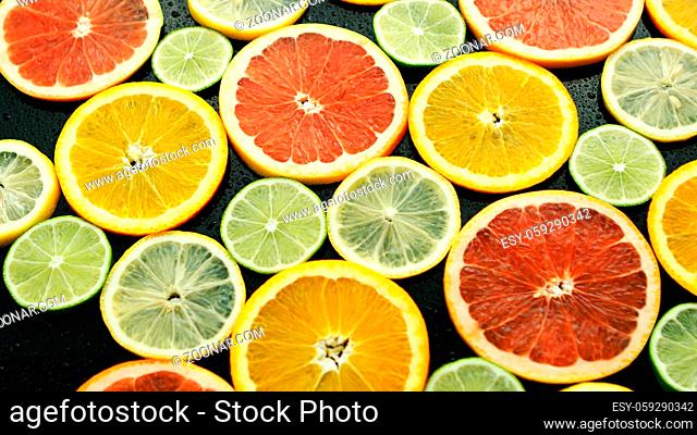 From above assortment of sliced lime, lemon, grapefruit and orange on dark background