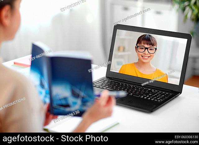 teacher with book and student on laptop screen