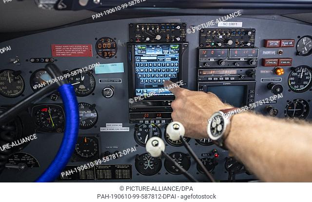 10 June 2019, North Rhine-Westphalia, Büren: The flight captain of a Douglas DC-3 operates a digital instrument panel in the cockpit