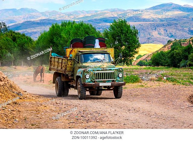 Old loaded soviet truck driving on local road in Kazakh steppe