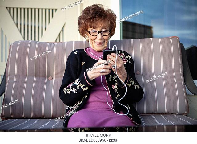 Senior Caucasian woman listening to mp3 player