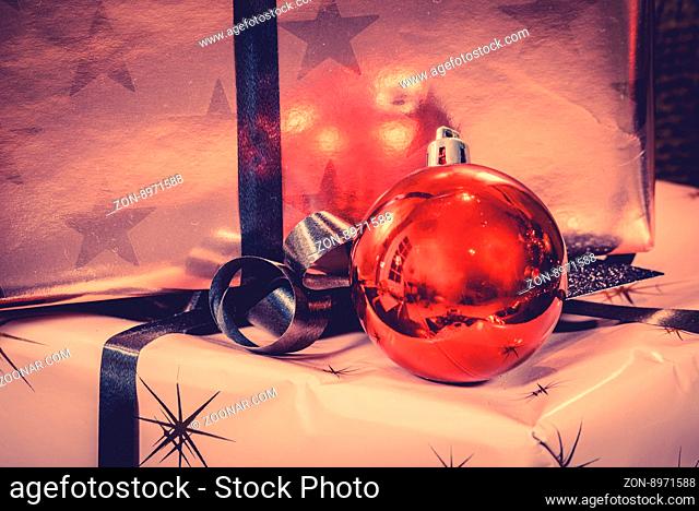 Xmas ornament with a red baubel on gift boxes