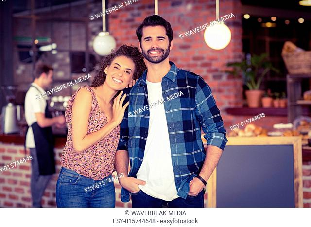 Smiling hipster couple in front of barista