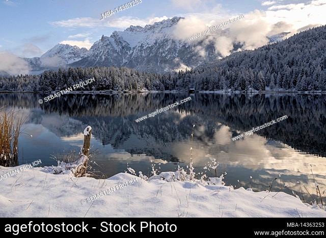 Winter at the Lautersee with snow and reflection of the Karwendel mountain range above Mittenwald in the afternoon in winter