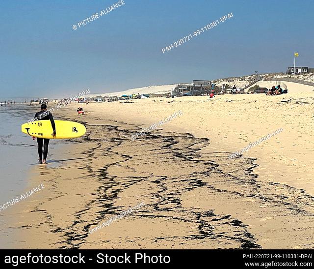 21 July 2022, France, Biscarrosse: Ash and burnt wood particles wash up on the beach of Biscarosse Plage, about 80 kilometers southwest of Bordeaux