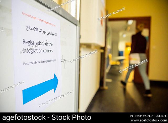09 November 2023, Berlin: A sign for registering for integration courses stands in the stairwell in front of the entrance to a Berlin language school